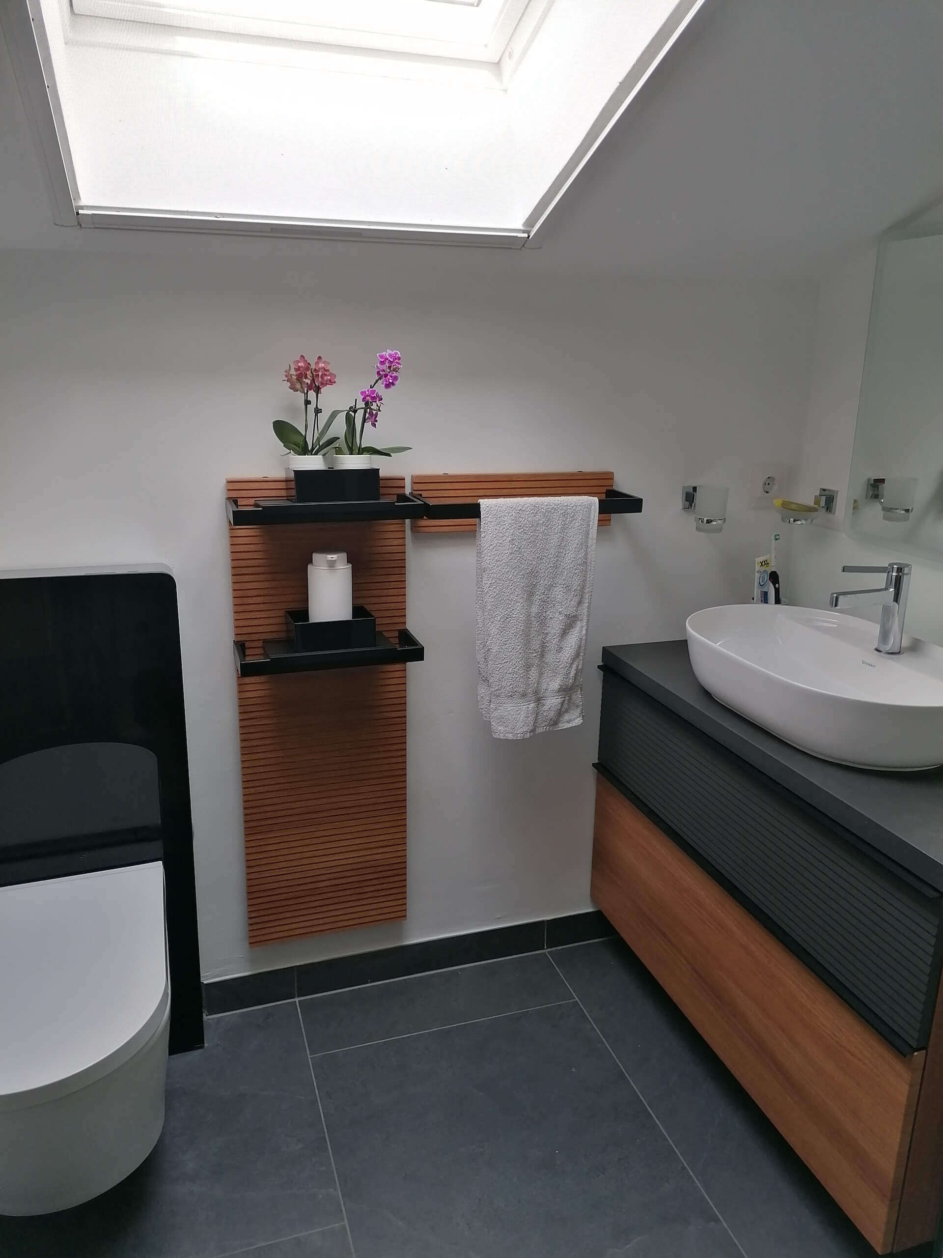 Modernes Badezimmer mit Waschbecken und Dachfenster, ideal für Heizungs- und Sanitärlösungen.