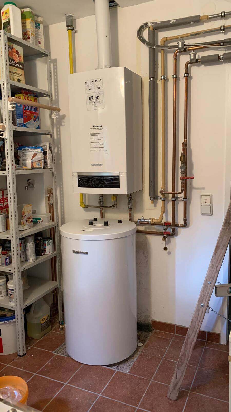 Heizungsanlage mit angeschlossenen Rohren in einem Wartungsraum eines Sanitärunternehmens für Heizung und Bäder.