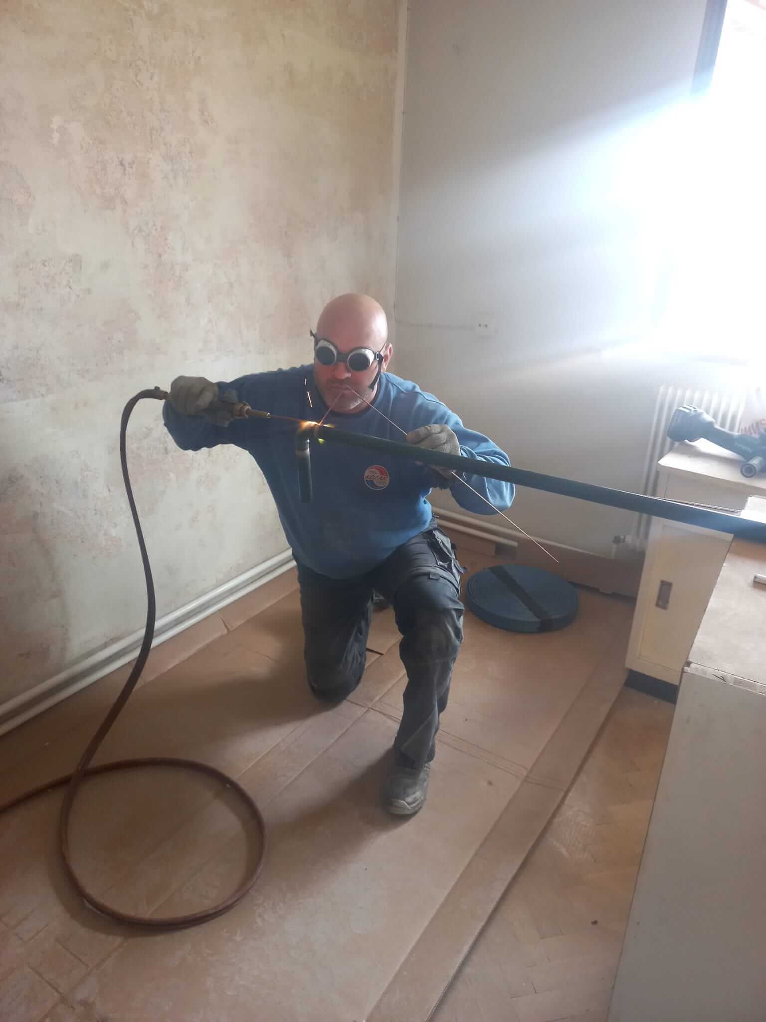 Handwerker schweißt Rohr, Sanitäre Instandhaltung, Heizung und Bäder Service im Einsatz.