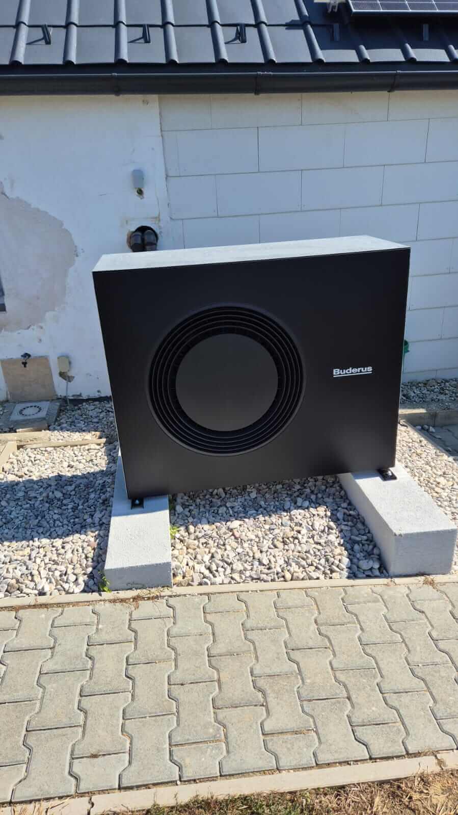 Moderne Wärmepumpe im Außenbereich installiert, Symbol für nachhaltige Heizlösungen des Sanitärunternehmens.