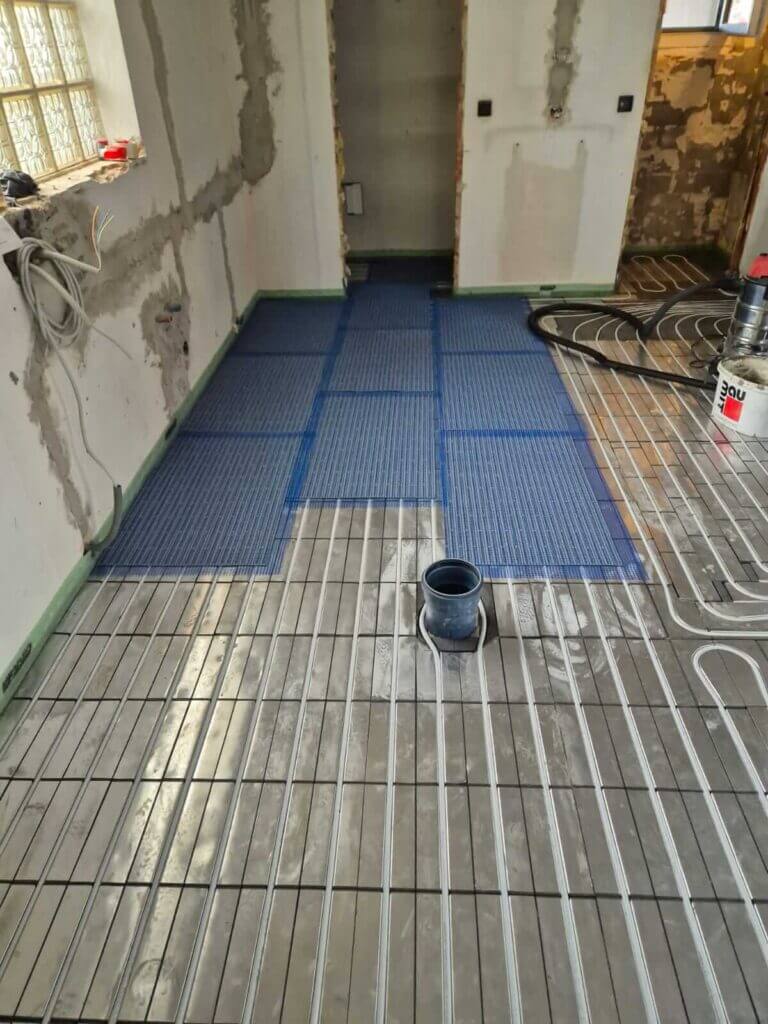 Installation von Fußbodenheizung in einem Badezimmer von einem Sanitärunternehmen.