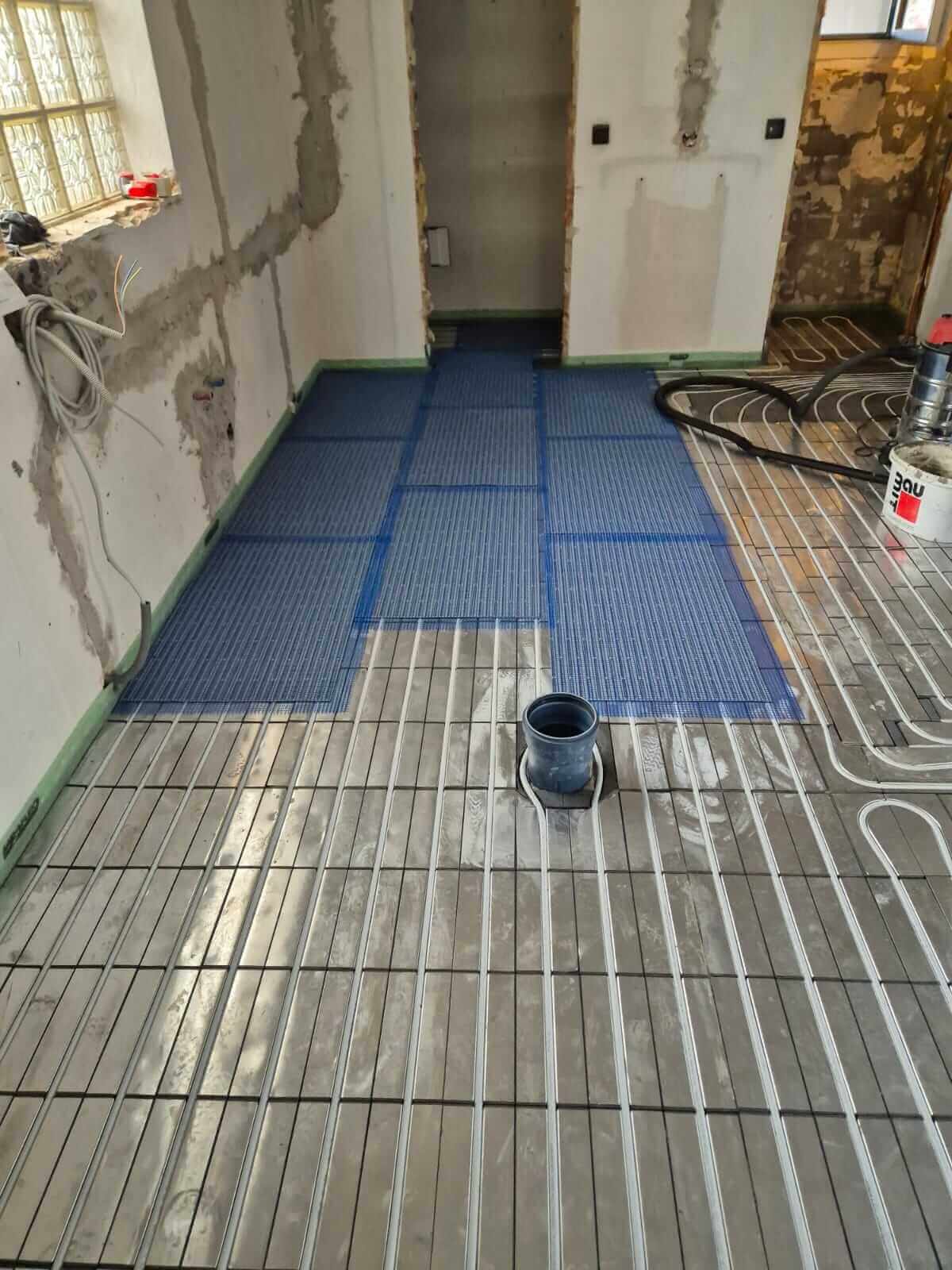 Installation von Fußbodenheizung in einem Badezimmer von einem Sanitärunternehmen.