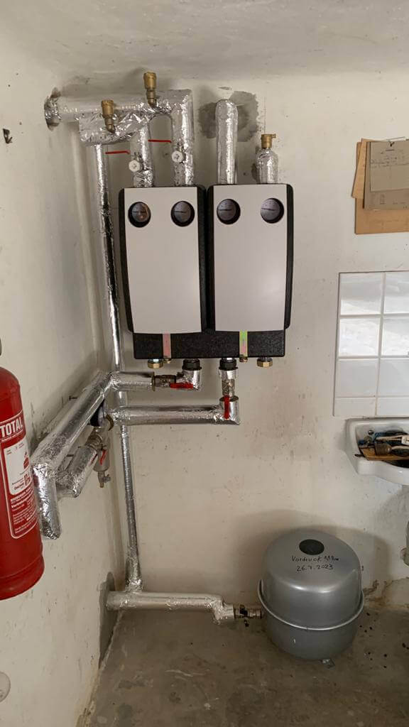 Moderne Heizungsinstallation in einem Wartungsraum, spezialisiert auf Sanitärtechnik und Energieeffizienz.